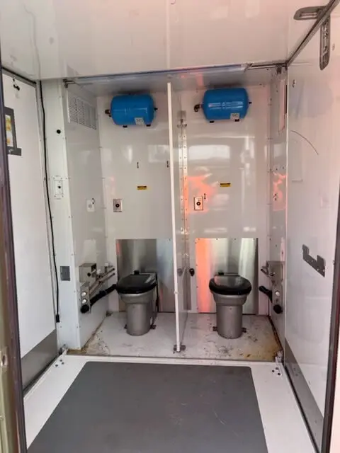 Inside a restroom trailer with two toilet stalls